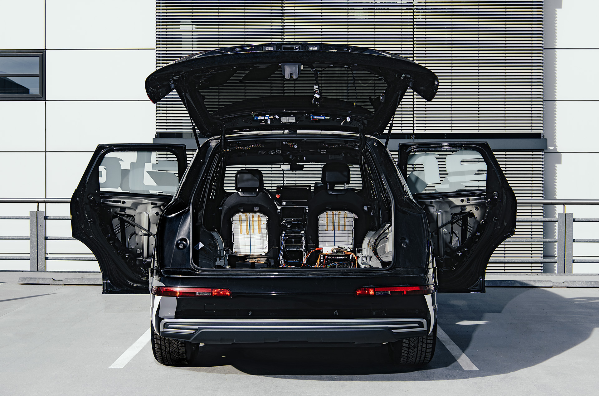 Una vista desde la parte trasera del concept car Brutus con el portón trasero y las puertas laterales abiertas para revelar la electrónica en el maletero y los paneles interiores retirados.