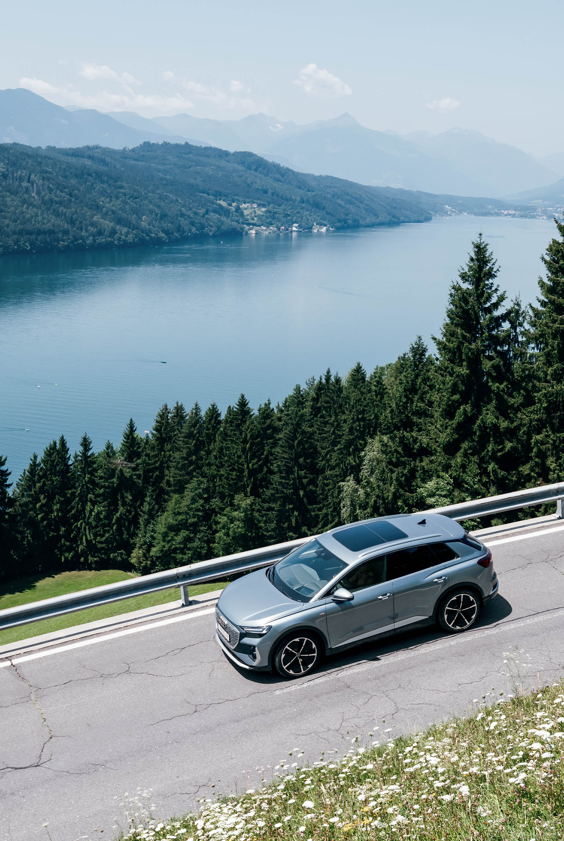 Una vista de un Audi Q4 e-tron en movimiento junto a un lago.